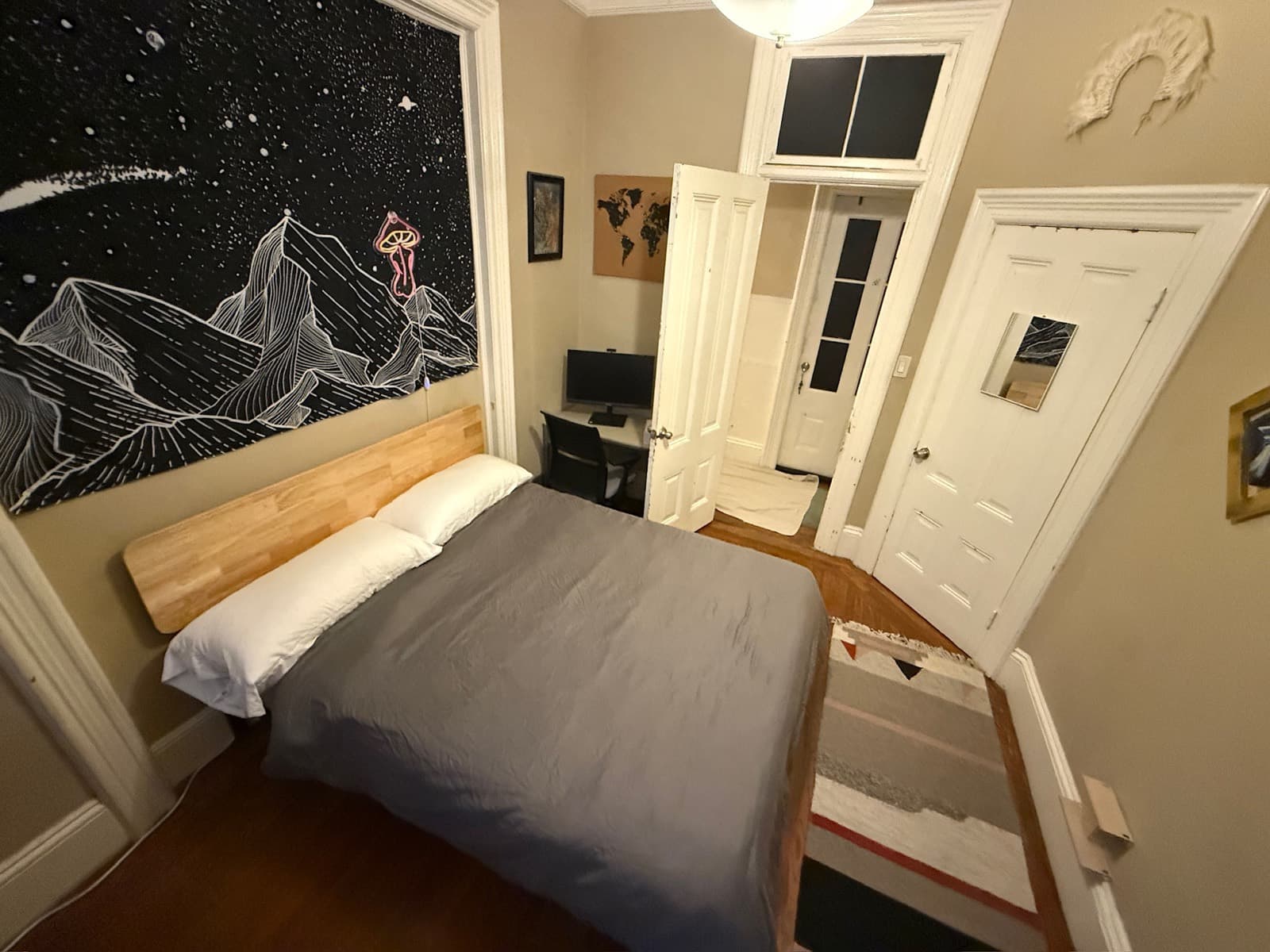 Private bedroom with a space-themed mural and a wooden bed
